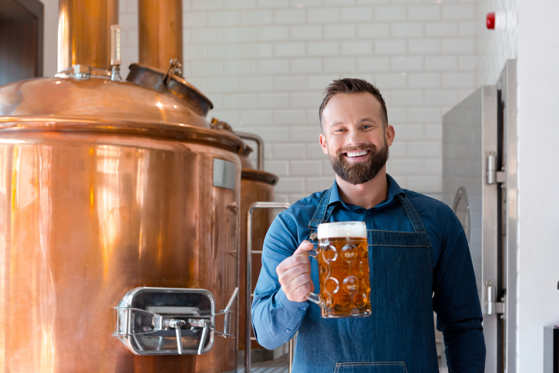 Master brewer with beer mug in microbrewery